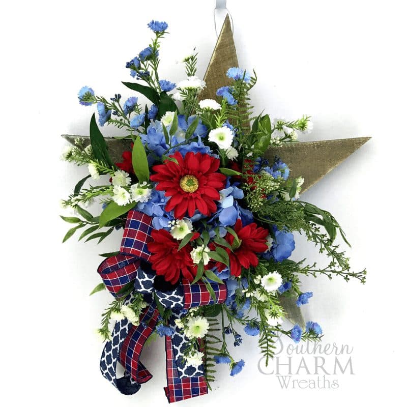 In this video, Julie shows you how to make a patriotic door hanger using wooden star and silk flowers.