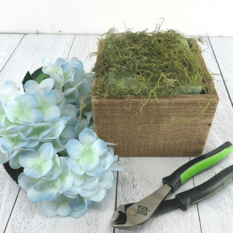 prepping a floral arrangement container with foam and moss