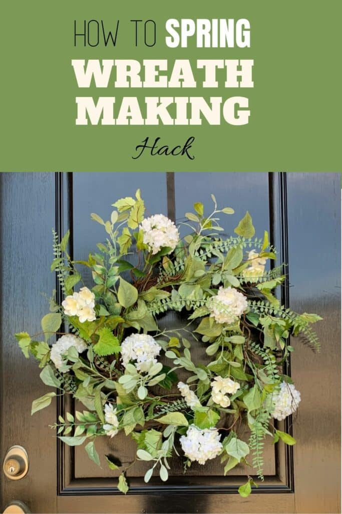 A spring wreath on a front door with white flowers