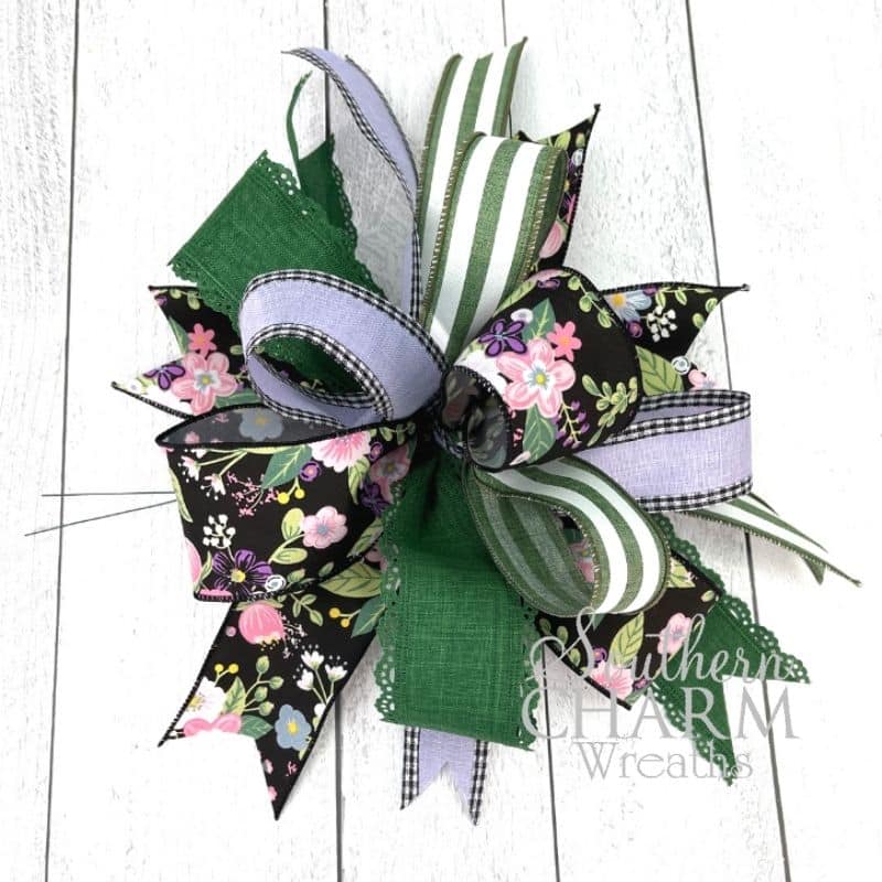 four ribbon bow with black, green, and purple ribbons