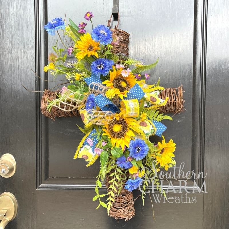 A DIY cross wreath with yellow and blue colors in support of Ukraine