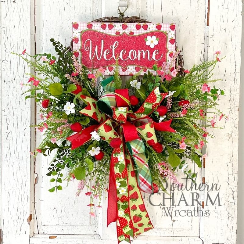 green and red strawberry themed wreath on white door