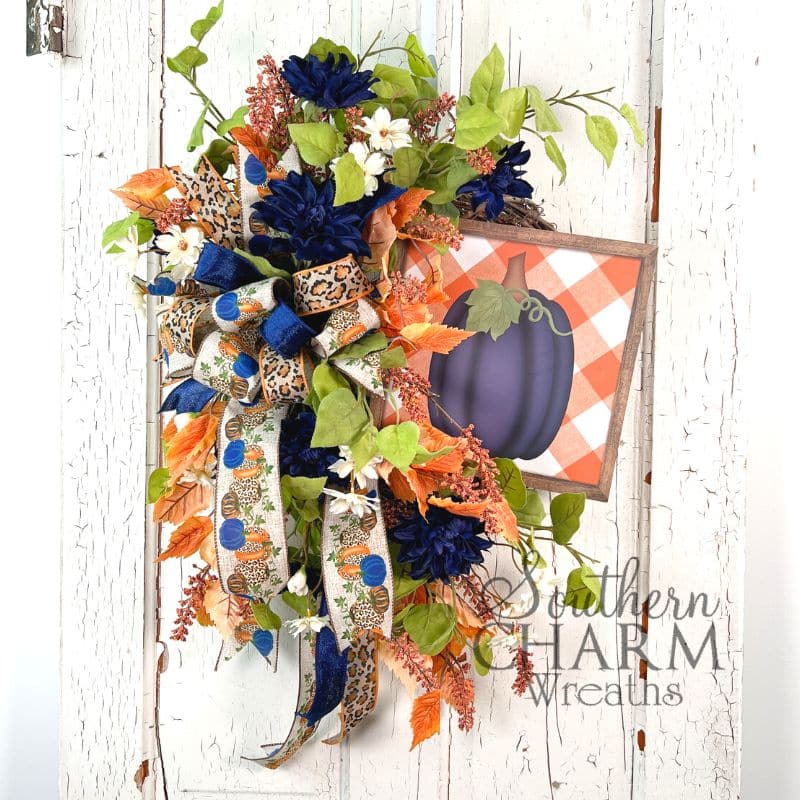 A silk flower navy pumpkin wreath on grapevine