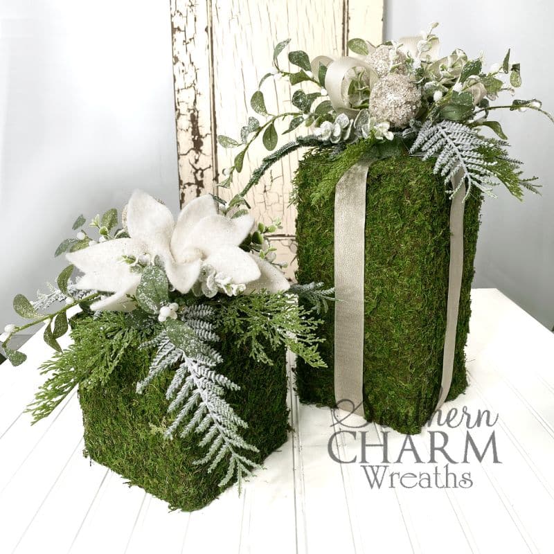 moss covered holiday gifts on white table
