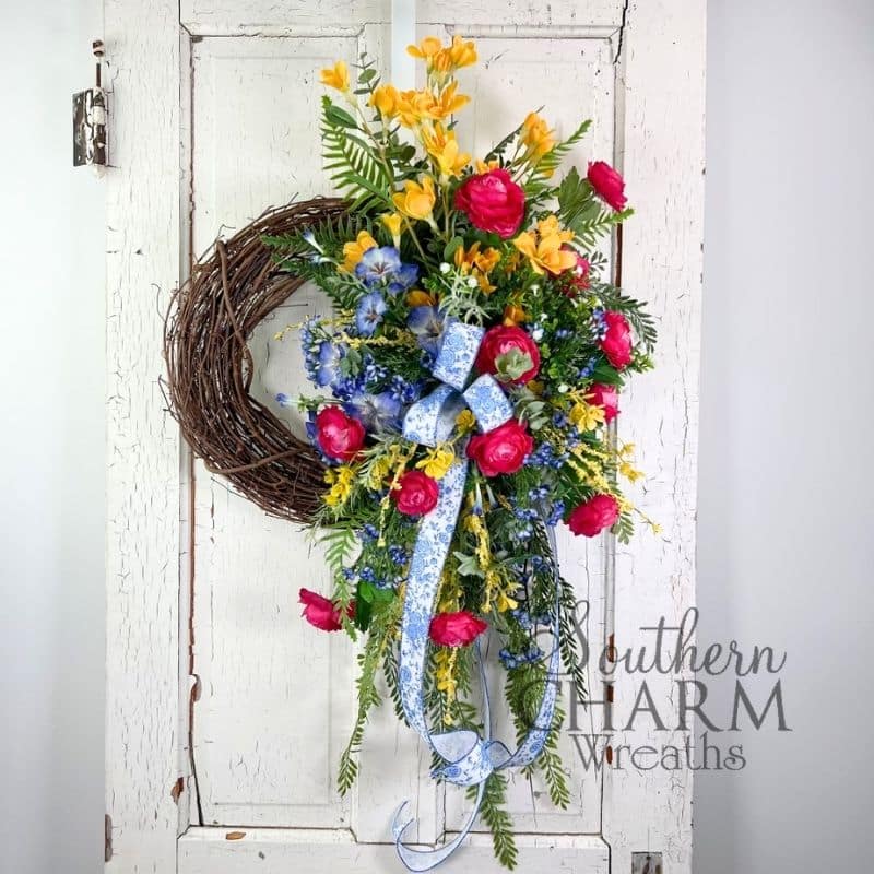 spring ranunculus wreath arrangement on white door
