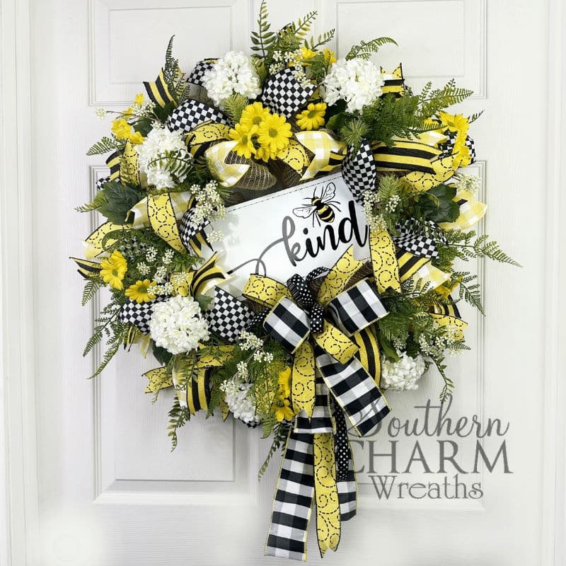 black and yellow bee themed wreath on white door