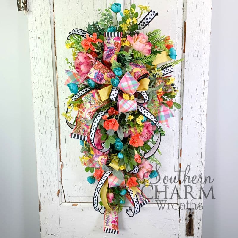 bright and colorful teardrop swag wreath on white door