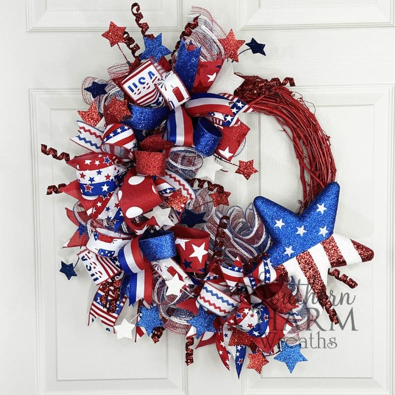 red white and blue themed patriotic wreath on red grapevine