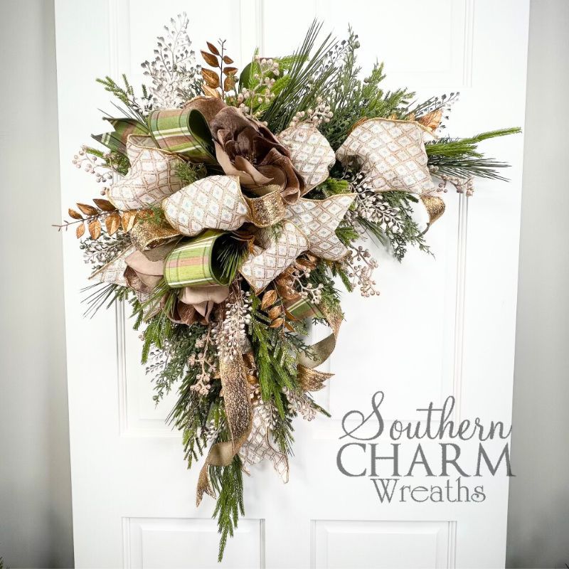 A champagne colored magnolia holiday corner swag wreath on a door.