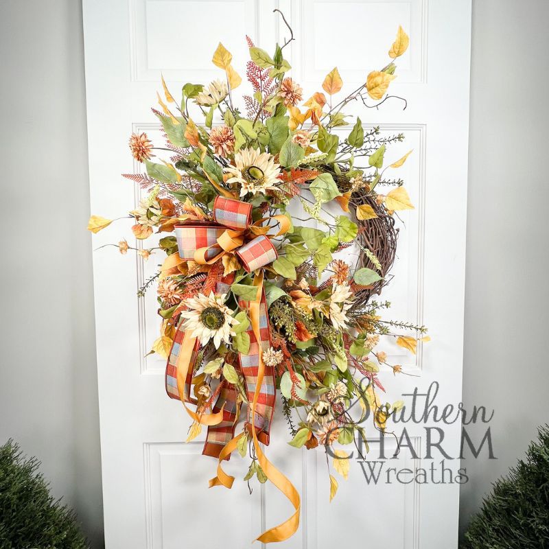 fall sunflower wreath on grapevine base, hanging on a door