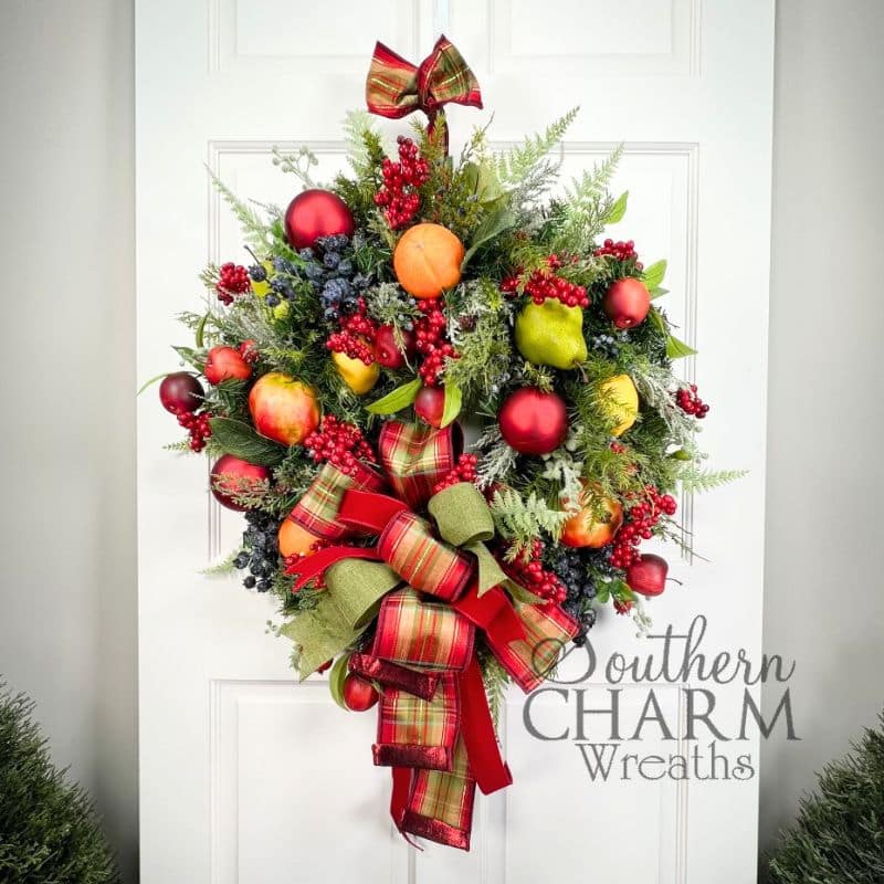 williamsburg style christmas wreath with fruit on white door