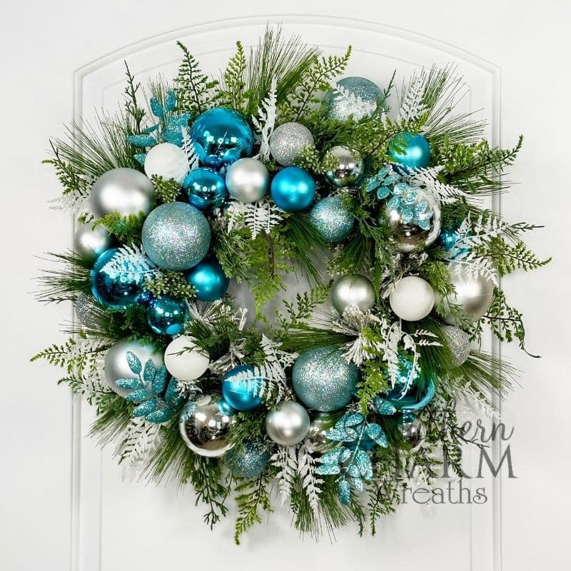 silver and blue holiday ornament wreath hung on a door