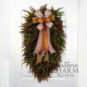 oval fall greenery wreath hanging on a door