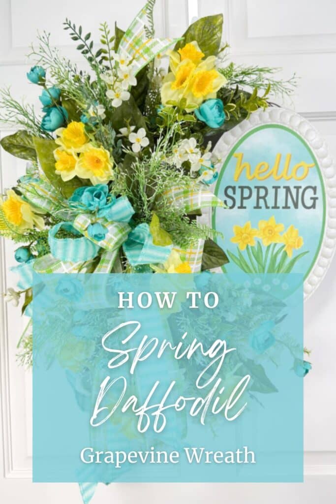 A spring grapevine wreath decorated with yellow daffodils, teal roses, white floral accents, and a pastel plaid bow.