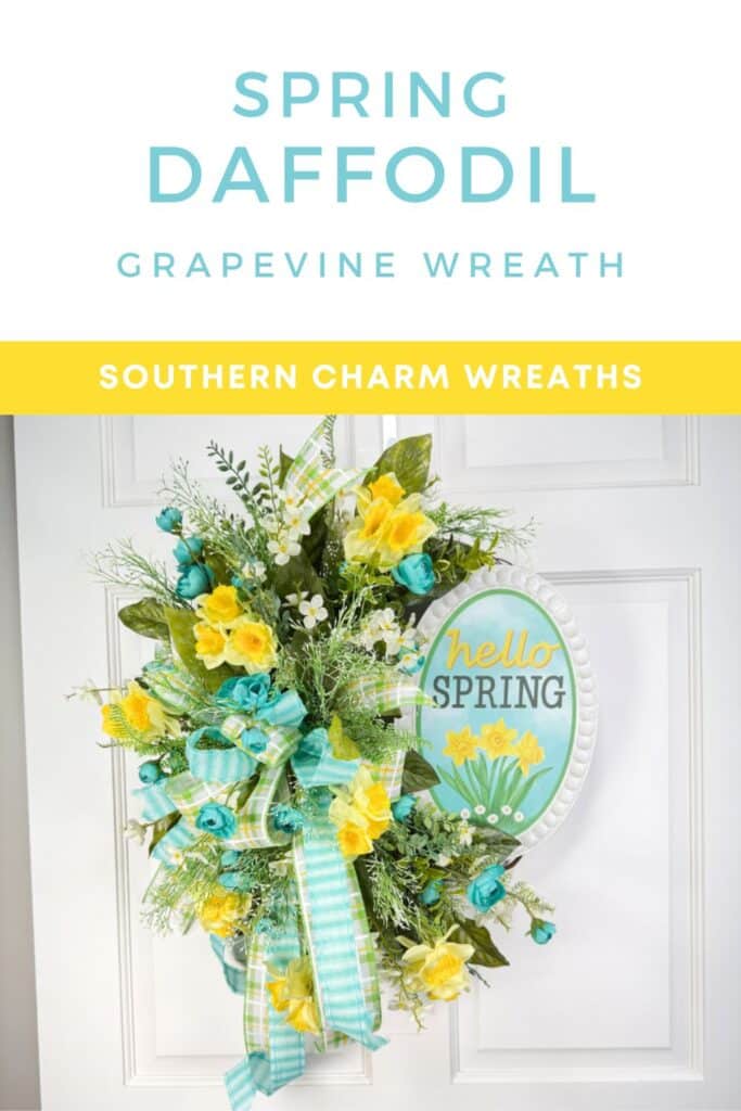 A handmade spring wreath featuring a mix of daffodils, teal florals, and greenery, accented with a large plaid bow and a pastel "Hello Spring" sign.