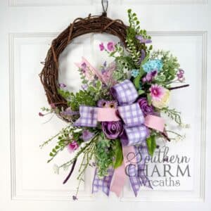 lavender grapevine wreath hanging on a white door