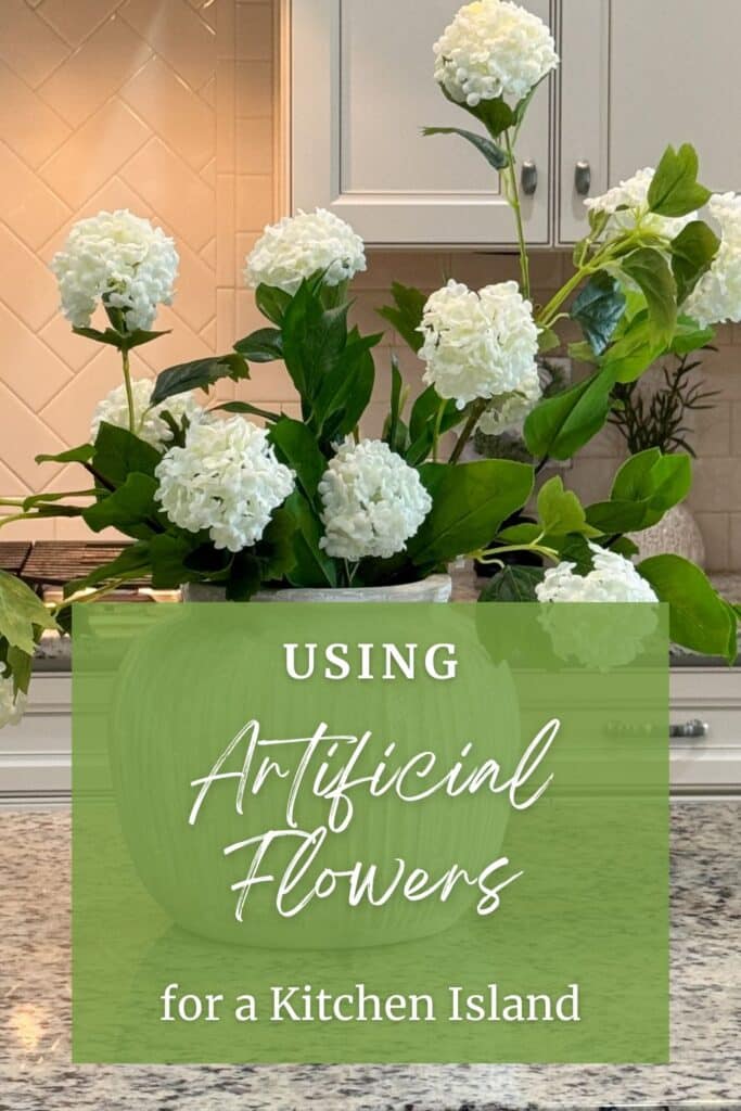Graphic pin showing an artificial hydrangea arrangement on a kitchen island with text overlay reading Using Artificial Flowers for a Kitchen Island.