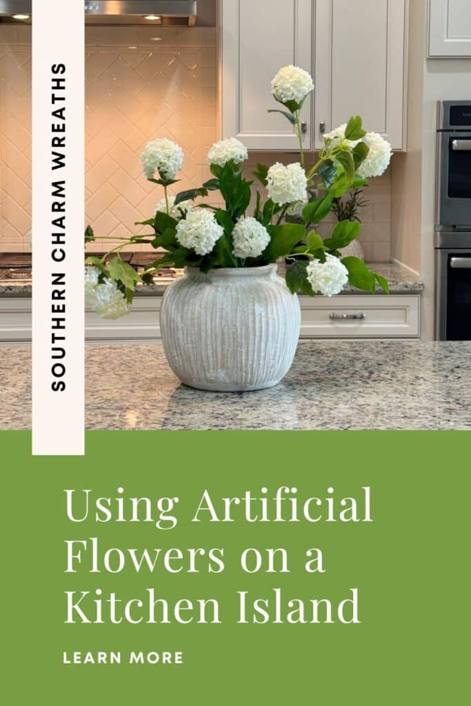Snowball hydrangeas arranged in a textured ceramic vase on a kitchen island with text overlay reading How to Artificial Flowers Kitchen Island.