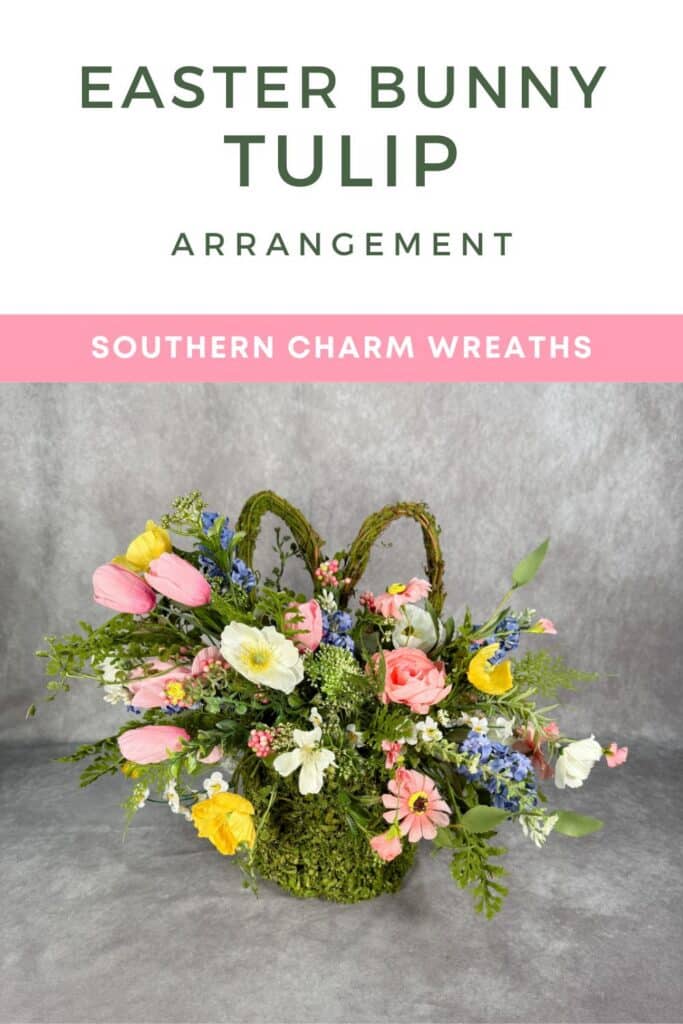 Easter Bunny Tulip Arrangement Pinterest pin with dark forest green bold title text at top, pink Southern Charm Wreaths banner, and full product photo of a moss grapevine bunny basket overflowing with pink tulips, yellow poppies, peach ranunculus, white anemones, blue delphinium, and cascading mixed greenery on a gray background