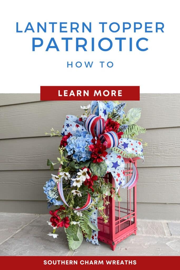Patriotic silk flower lantern topper with blue hydrangeas, red geraniums, white daisy filler, mixed greenery, and a layered star-print and red-white-blue striped ribbon bow, displayed on a red metal lantern on a stone porch — Southern Charm Wreaths DIY tutorial by Julie Siomacco