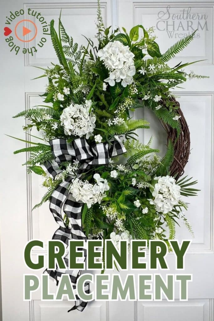 Grapevine wreath with greenery, hydrangeas, and checkered ribbon.