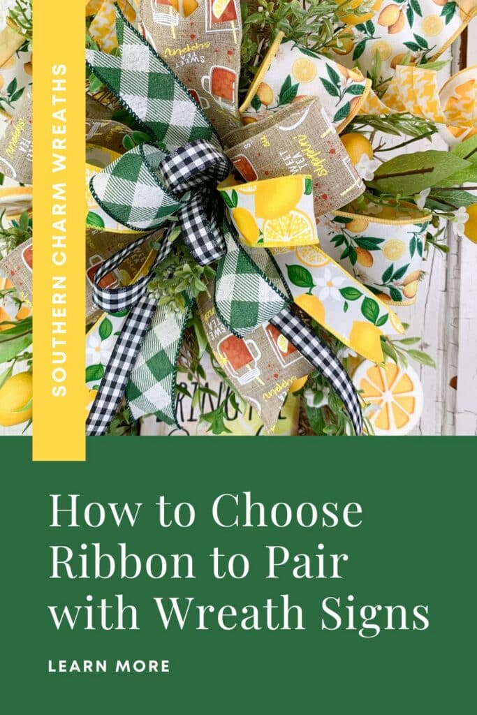 Close-up of a layered wreath bow made from four coordinated wired ribbons — a wide lemon-print ribbon, a burlap sweet tea print ribbon, a green buffalo check, and a narrow black and white buffalo check — all pulled from the colors and patterns of the wreath sign below. Mixed greenery surrounds the bow. A yellow vertical banner on the left reads Southern Charm Wreaths. A dark green footer block reads: How to Choose Ribbon to Pair with Wreath Signs, with Learn More below in white caps.