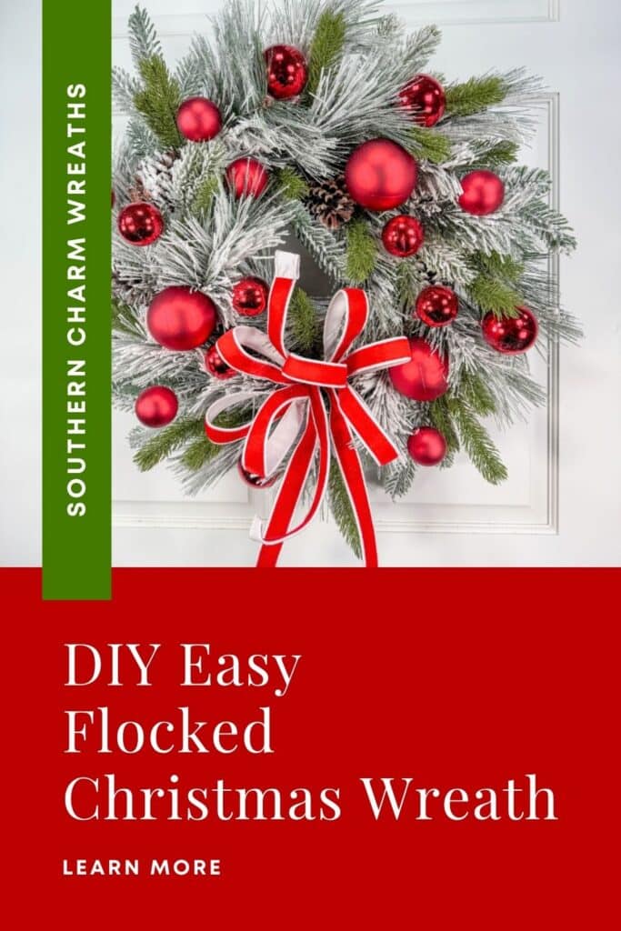Red and white flocked Christmas wreath with red ornaments and a velvet bow on a white door, with a vertical green Southern Charm Wreaths banner and a red block reading DIY Easy Flocked Christmas Wreath, Learn More.