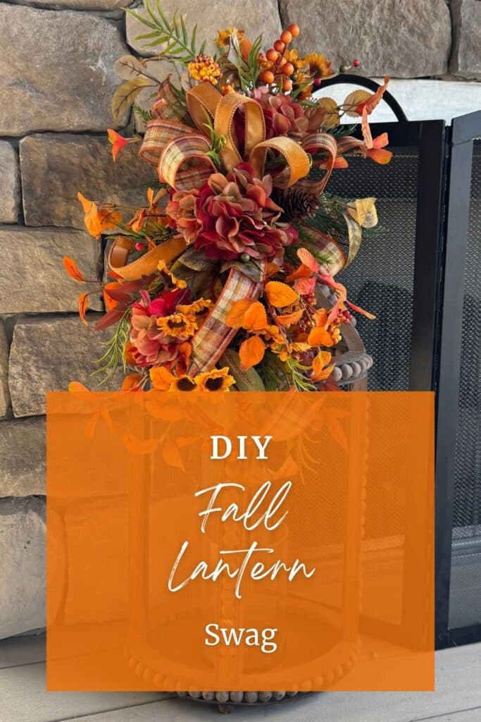 DIY fall lantern swag with rust and burgundy silk hydrangeas, mini sunflowers, orange fall leaves, berries, and a plaid and orange velvet ribbon bow, shown against a stone fireplace.