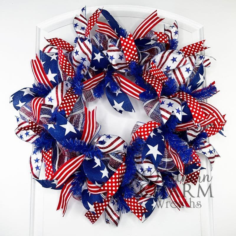 red white and blue patriotic deco mesh wreath on a door