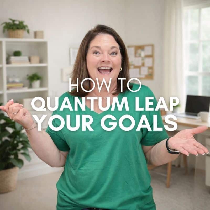 Julie smiling with arms open in home office setting with text overlay “How to Quantum Leap Your Goals.”